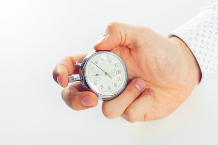 Close up of hand holding stopwatch, isolated on white backgroundの写真素材