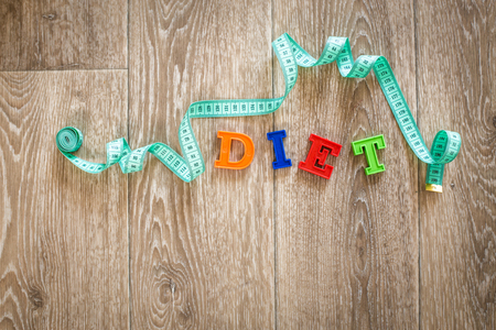measuring tape on a wooden background. diet conceptの写真素材