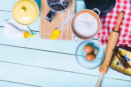 Preparation of the dough. Ingredients for the dough - Eggs and flour with a rolling pin. On wooden background.の写真素材