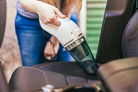 Woman Cleaning Interior Of Car Using Vacuum Cleanerの写真素材