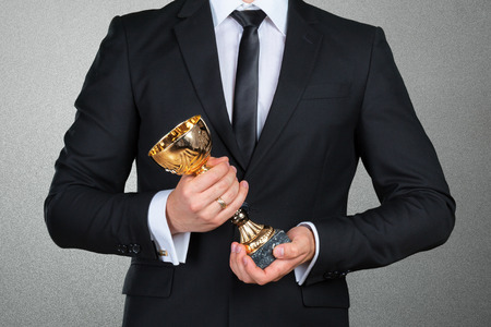 Businessman holding golden cup trophyの写真素材