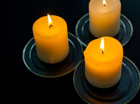 closeup to burning candles in darknessの写真素材