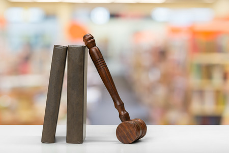 Wooden gavel and books on wooden table