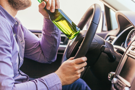 man drinking alcohol while driving the carの写真素材