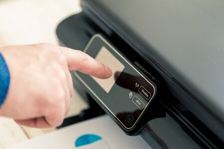 Man's hand making copies. Working with printerの写真素材