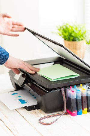Man's hand making copies. Working with printer