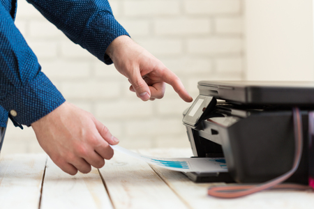 Man's hand making copies. Working with printer