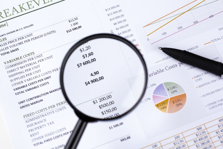 financial documents with magnifying glass over them