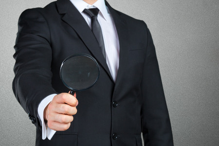 business man holding magnifying glass conceptの写真素材