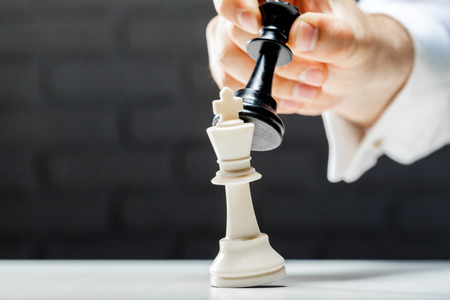 Hand of businessman playing chess