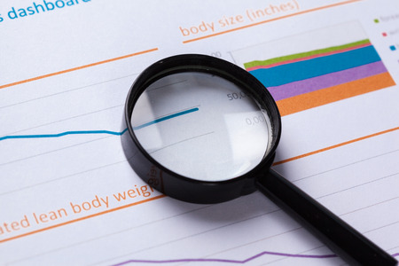 financial documents with magnifying glass over them