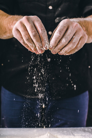 adult man hands work with flour, dark photoの写真素材