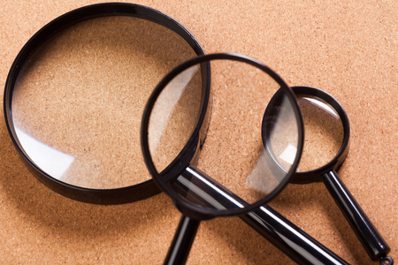 blank brown board and a magnifying glassの写真素材