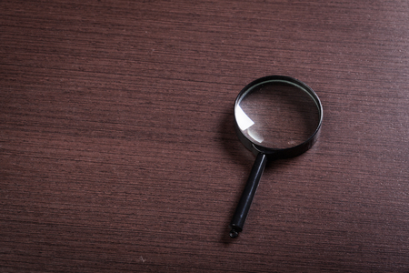 magnifying glass on the wooden backgroundの写真素材