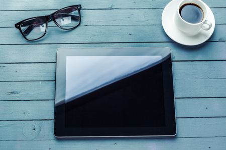 digital tablet and coffee cup on wooden tableの写真素材