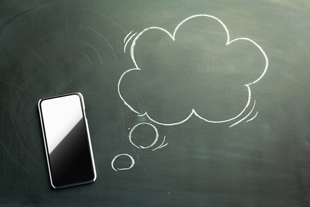 Smartphone with blank bubble drawn on the black chalkboardの写真素材