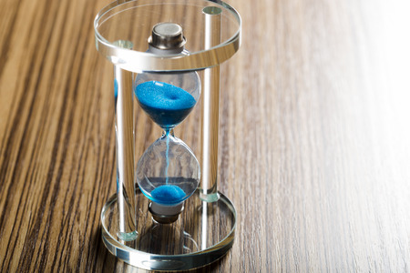 Time is passing. Blue hourglass close up