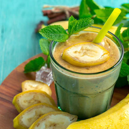 Banana smoothie and fresh banana on wooden background.の写真素材