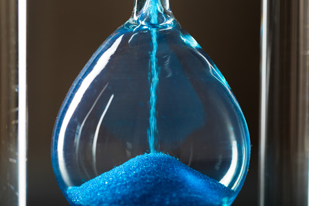 Time is passing. Blue hourglass close up