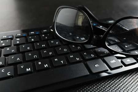 eyeglasses and keyboard on the tableの写真素材