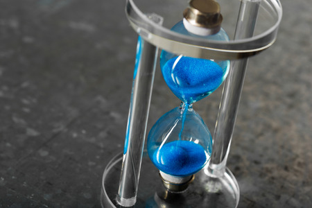 Time is passing. Blue hourglass close upの写真素材