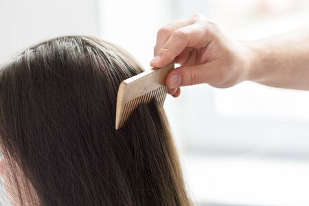 Hairdresser does hair style of womanの写真素材
