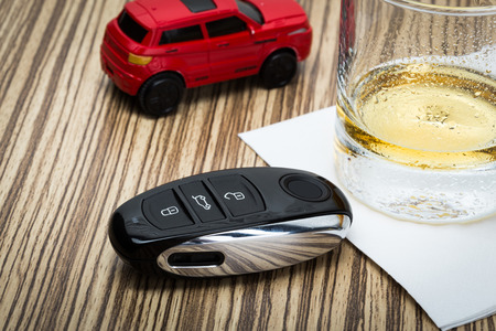 toy car and glass of whiskey metaphor crash accident isolated on whiteの写真素材