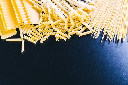 Raw spaghetti on black wooden background, top viewの写真素材