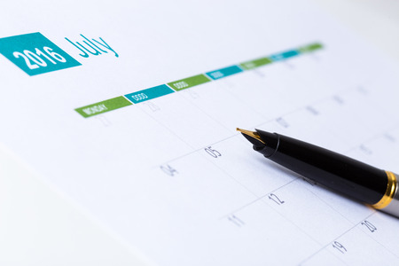 sheet of a calendar and a pen close-up