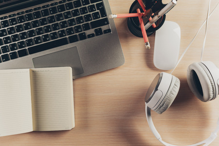 Mix of office supplies and gadgets on a wooden table background.