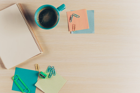 Top view workspace with blank notebook and pen on wooden table