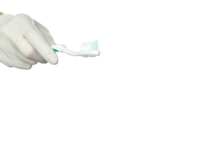 Gloved doctor's hand holding a toothbrushの写真素材