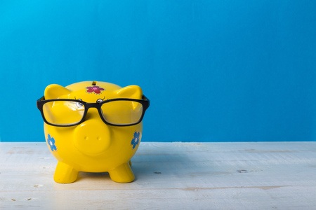 Yellow piggy bank  on blue backgroundの写真素材
