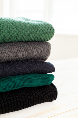 Stack of white cozy knitted sweatersの写真素材