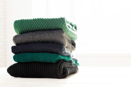 Stack of white cozy knitted sweaters