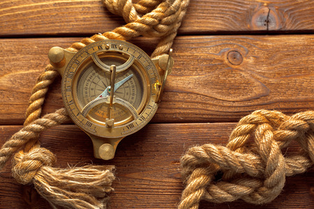 Compass and rope on wooden table. close upの写真素材
