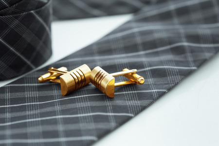 tie and cufflinks on the table .