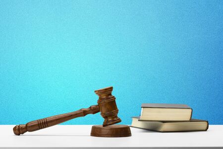 Wooden gavel and books on wooden table