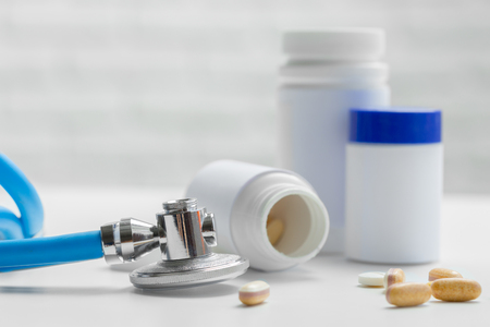 pills or capsules and stethoscope on the white table. Concept healthcare.の写真素材