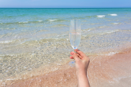 Glass of wine on beachの写真素材