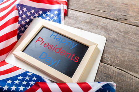 the text happy presidents day written in a chalkboard and a flag of the United Statesの写真素材