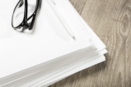 Blank notebook and pencil with glasses on wooden table