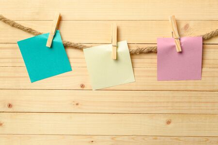 clothespin hanging with blank paper on wooden backgroundの写真素材