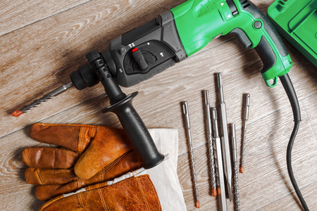 Electric hammer drill lies on a wooden table