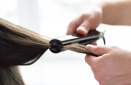 Hairdresser does hair style of womanの写真素材
