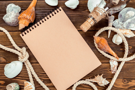 Shells and notepad on wooden table. Top view with copy spaceの写真素材