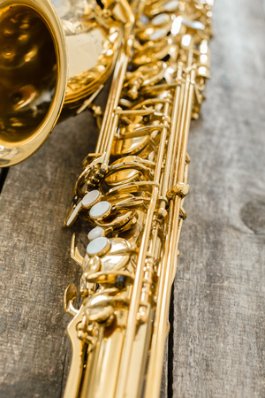 Beautiful golden saxophone on wooden backgroundの写真素材