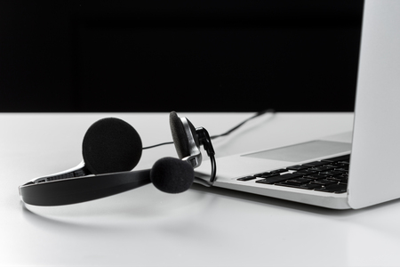 call center support concept. headset on keyboard computer laptopの写真素材