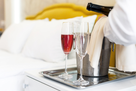 Honeymoon concept. Champagne bucket near bed in a hotel roomの写真素材