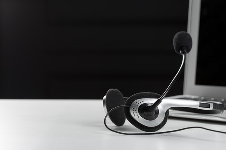 call center support concept. headset on keyboard computer laptopの写真素材